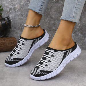 Sporty knit slip-on sneakers in black and white with a decorative lace pattern.