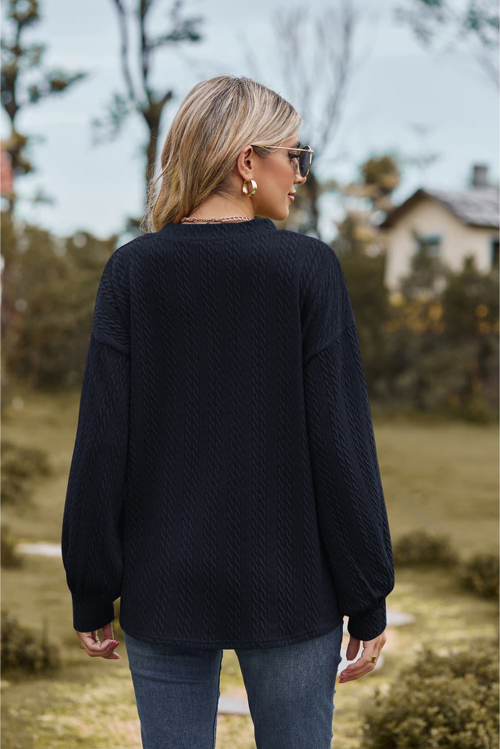 Dark blue textured cable knit v-neck sweater with balloon sleeves.