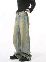 Distressed denim jeans in a medium wash with a relaxed fit and yellowed accents.