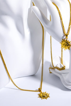 Gold sunburst pendant necklace with curb chain, detailed sun face charm.