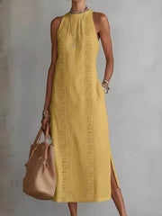 Yellow sleeveless midi dress with geometric trim and pockets, side slits.