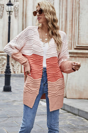 Ombre ribbed knit open cardigan in coral with a wavy pattern and open front.