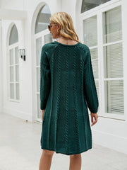 Cable knit A-line sweater dress in Black Forest with vertical cable details.
