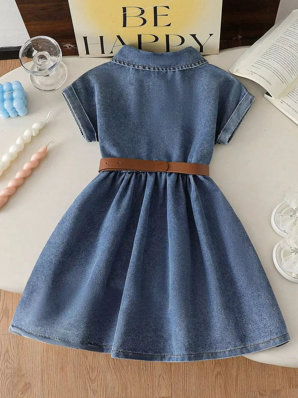 Blue denim dress with short sleeves, collar, and brown belt detail.
