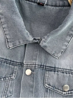 Light wash denim romper with button front and chest pockets.