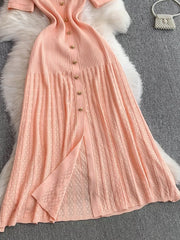 Pink ribbed knit midi dress with gold button detail and open knit skirt panel.