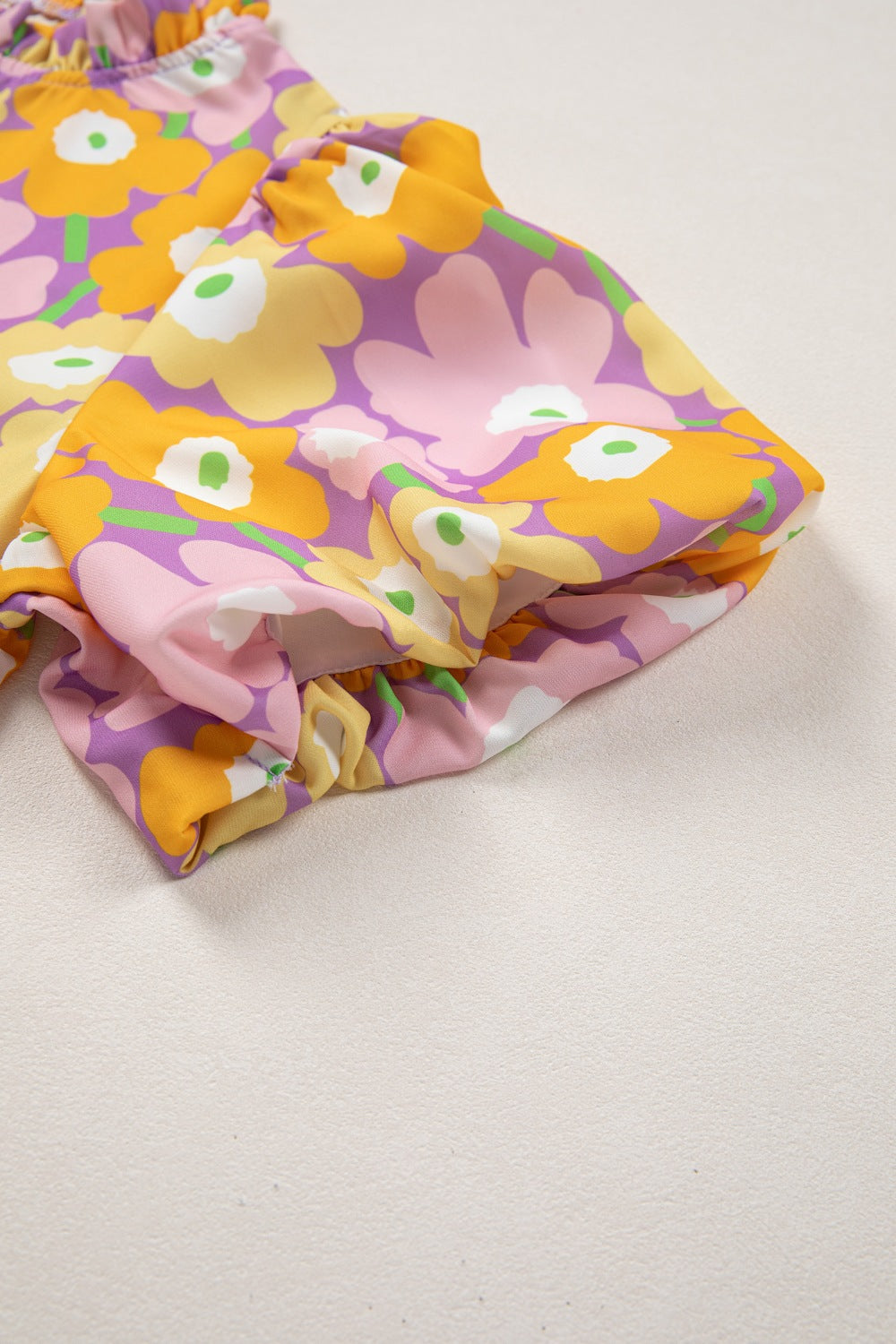 Puff sleeve blouse with ruffle trim in a colorful floral print.