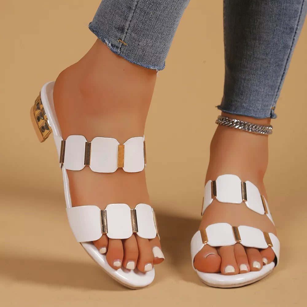 White block heel sandals with gold accent straps and a glossy finish.
