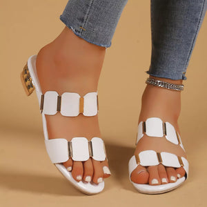 White block heel sandals with gold accent straps and a glossy finish.