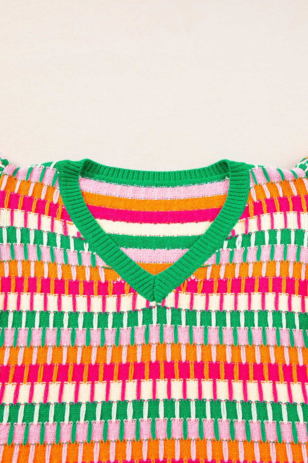 Geometric knit v-neck top in green, orange, pink, and white stripes with flutter sleeves.