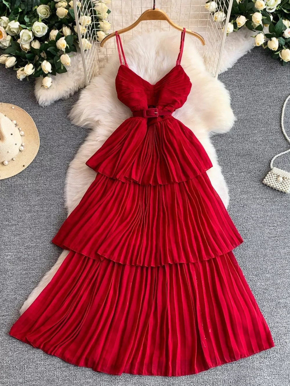 Red belted midi dress with spaghetti straps, tiered pleated skirt and V-neck bodice.