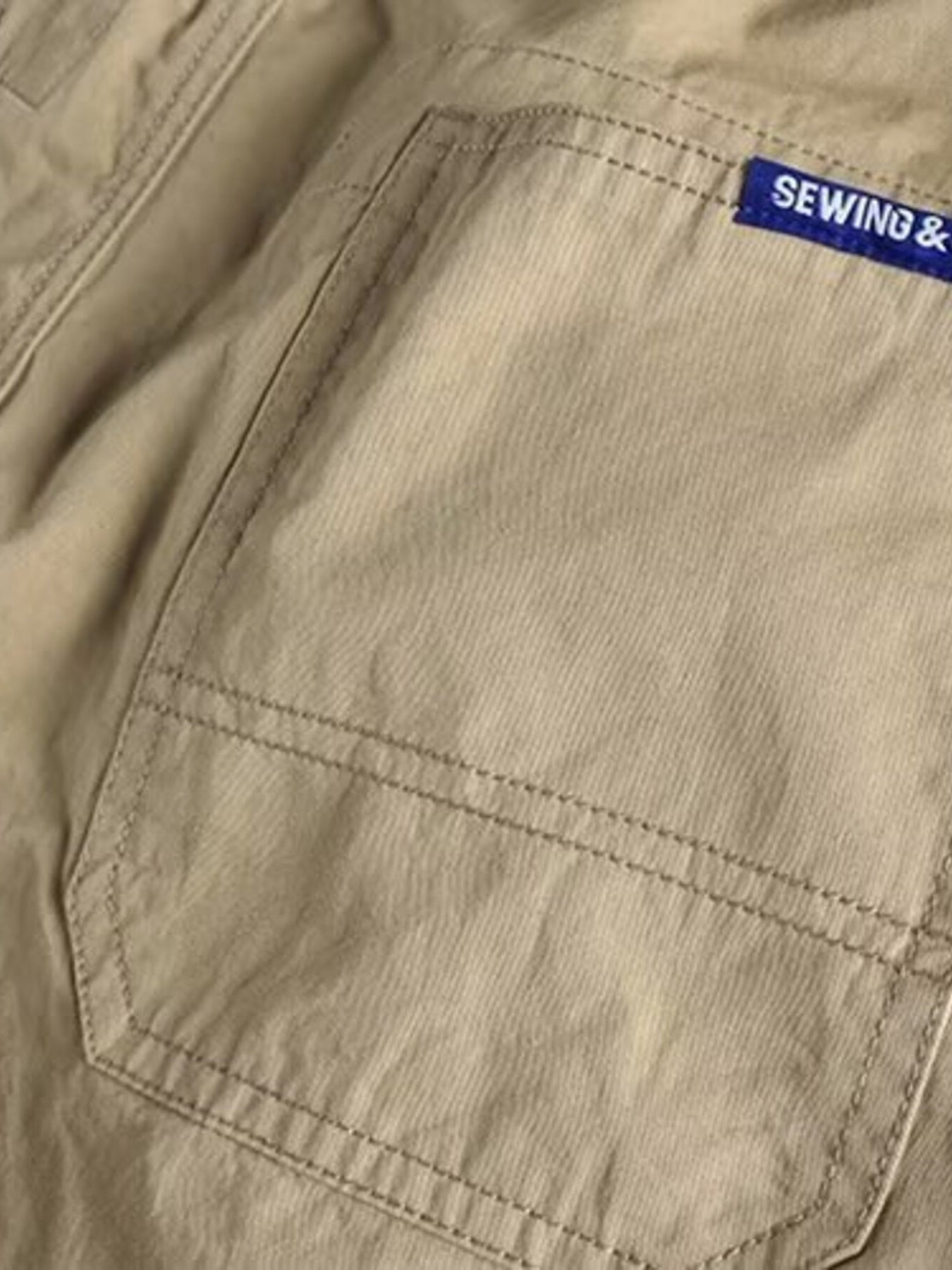 Khaki cargo pants with a back pocket detail and blue brand tag.