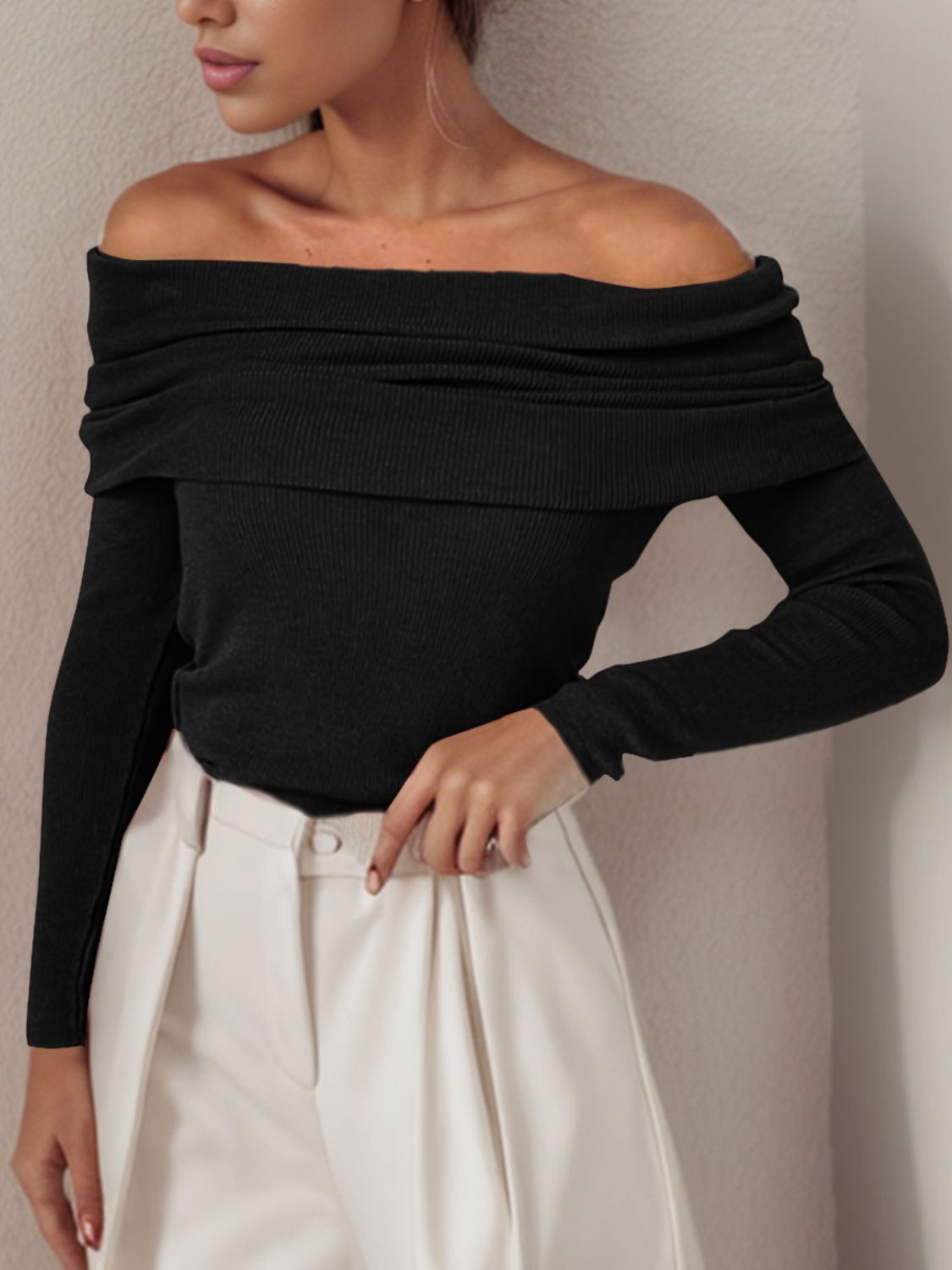 Black off the shoulder knit sweater with draped neckline and long sleeves.