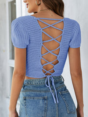 Blue crochet crop top with short sleeves and a lace-up back detail.