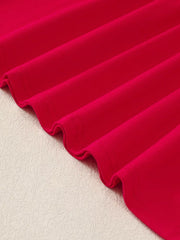 Red baby dress fabric detail with subtle texture and wavy hem
