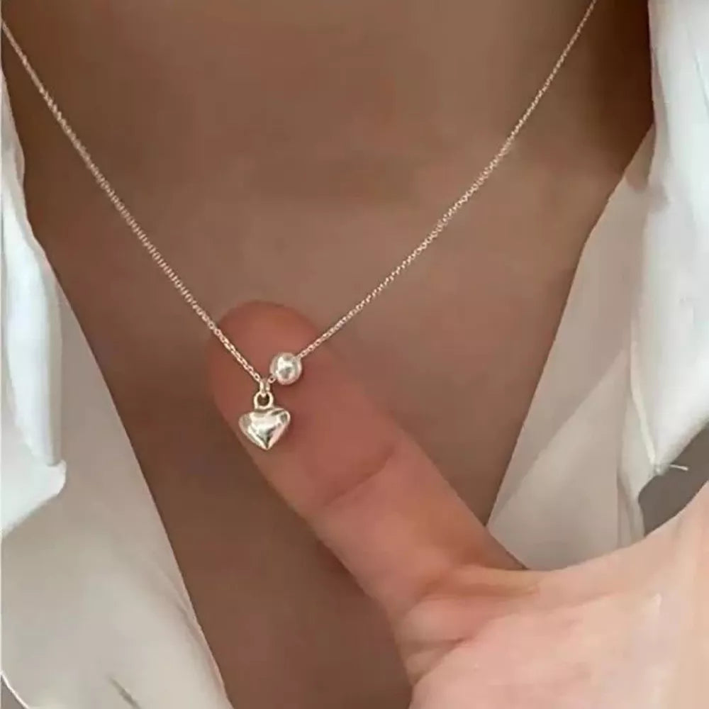 Delicate silver heart pendant necklace with pearl accent on chain