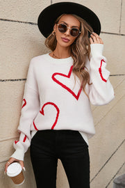 White acrylic knit jumper with red heart outline pattern, crew neck and long sleeves.