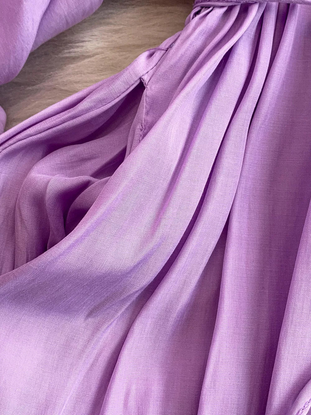 Purple polyester maxi dress with balloon sleeves and a slit detail.