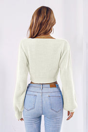 White acrylic knit crop sweater with balloon sleeves and tie-front detail.