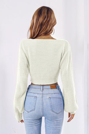 White acrylic knit crop sweater with balloon sleeves and tie-front detail.