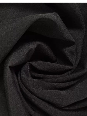 Black midi dress fabric detail, showing texture and drape.