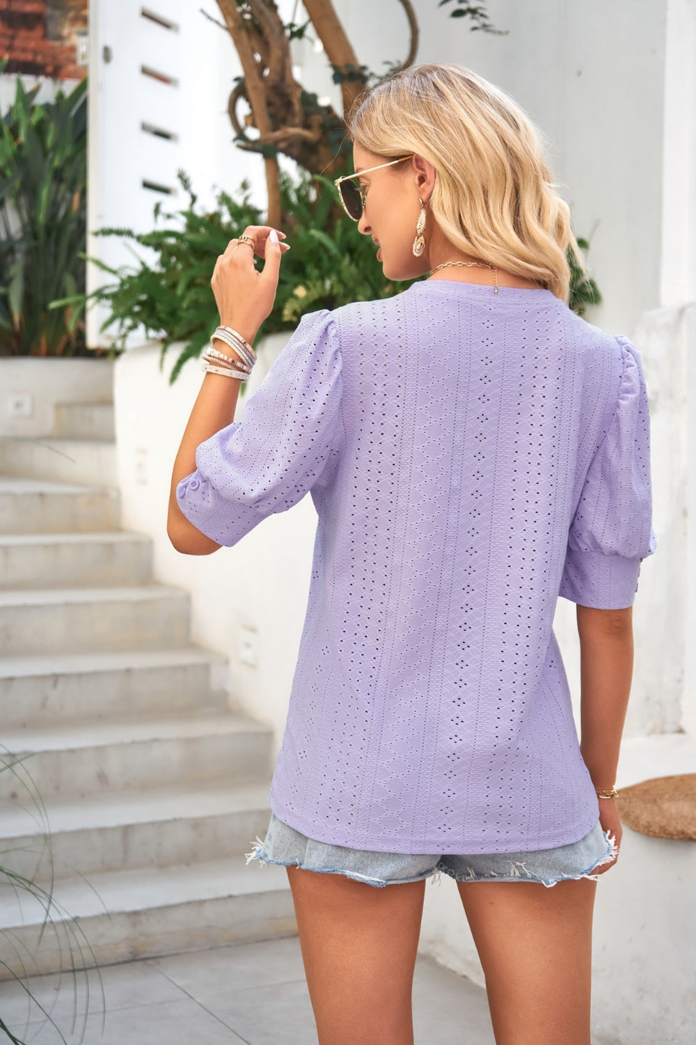 Lavender eyelet puff sleeve blouse with short sleeves and a round neckline.