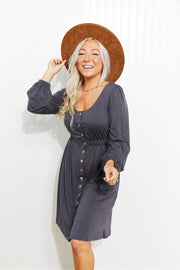 Gray button-down empire waist mini dress with long sleeves and a scoop neckline.