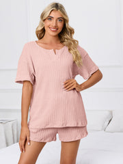 Blush pink ribbed knit lounge set with short sleeves and notch neck top and matching shorts.