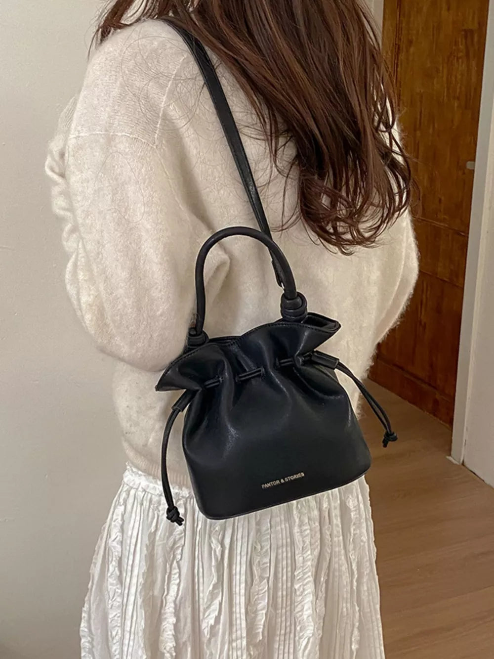 Drawstring Bucket Crossbody Bag in Black, model styling view