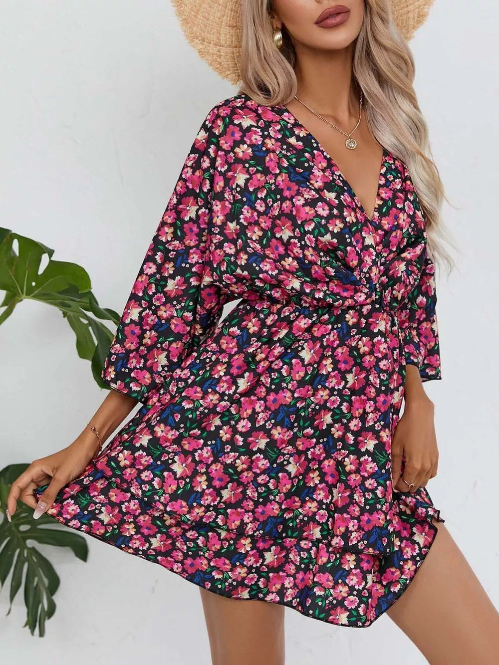 Black floral mini dress with v-neck, 3/4 sleeves, and ruffle hem.