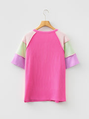 Color block t-shirt with pink, purple, green, and light pink patchwork sleeves and ribbed texture.
