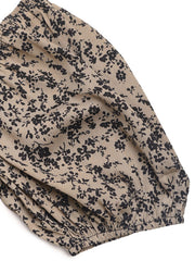 Smocked bodice floral palazzo jumpsuit in taupe with black floral print and elastic cuff detail.