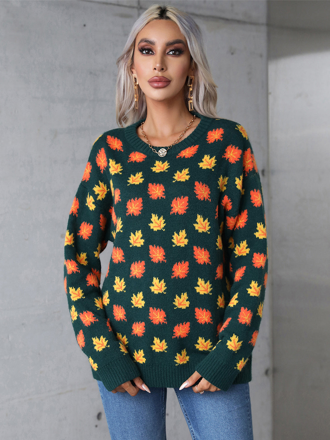 Dark green acrylic knit crewneck sweater with allover orange and yellow leaf pattern.
