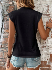 Black cap sleeve top with power shoulders, styled with distressed denim shorts.