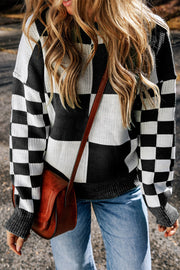 Colorblock checkerboard knit sweater in black and white with crew neck and long sleeves.