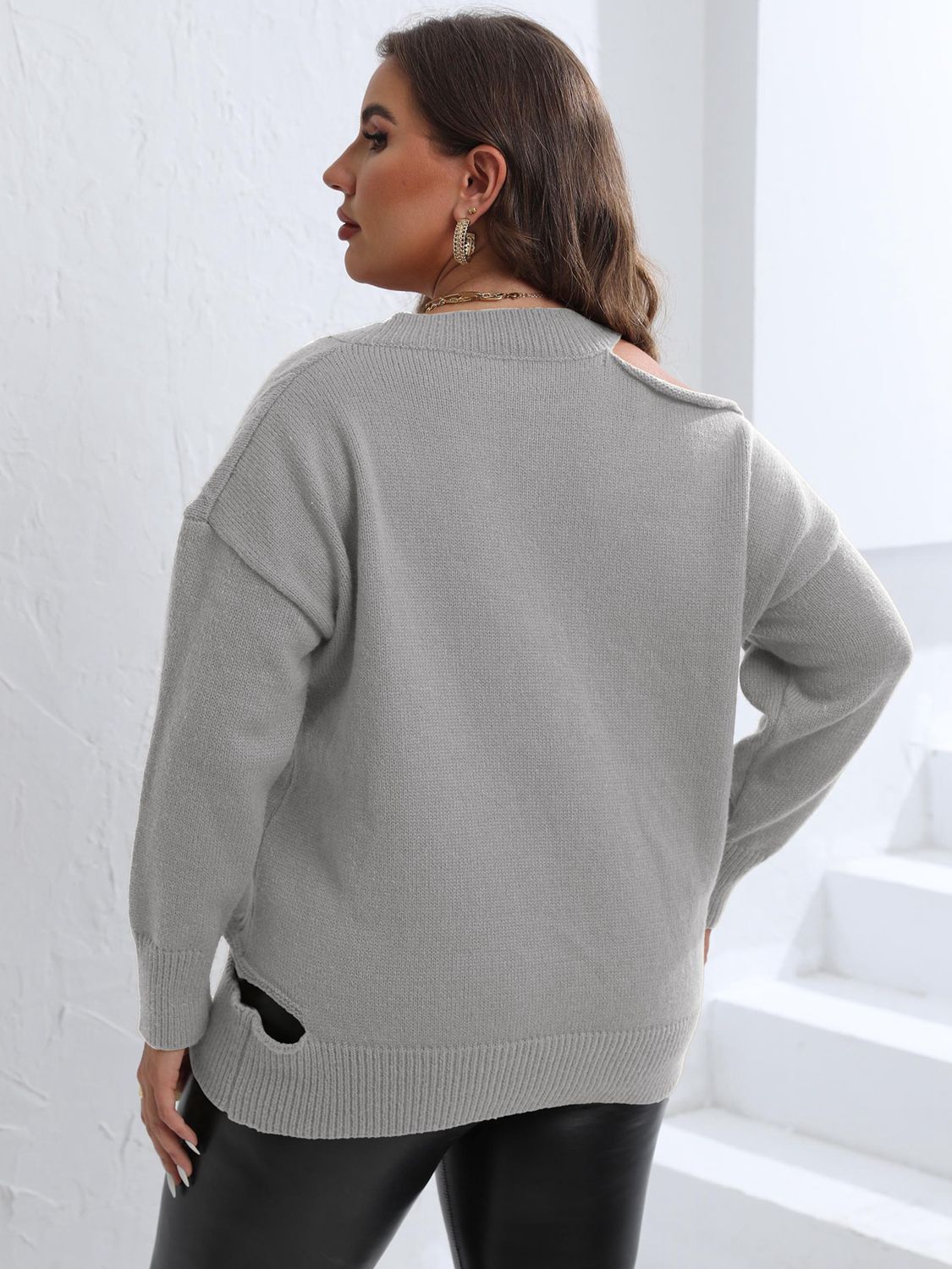 Light gray knit sweater with asymmetric shoulder detail and side slits.