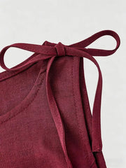 Burgundy tie-shoulder vest with subtle floral pattern and textured fabric.