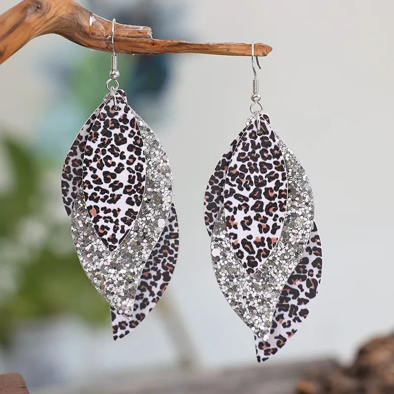 Leopard print layered drop earrings with glitter accents, gold and silver tones.