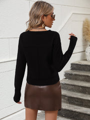 Black V-neck knit sweater with long sleeves and a relaxed fit.