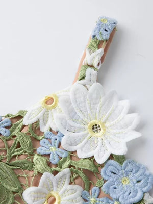 Maxi dress with embroidered floral appliqué detail on straps and bodice in white and blue.