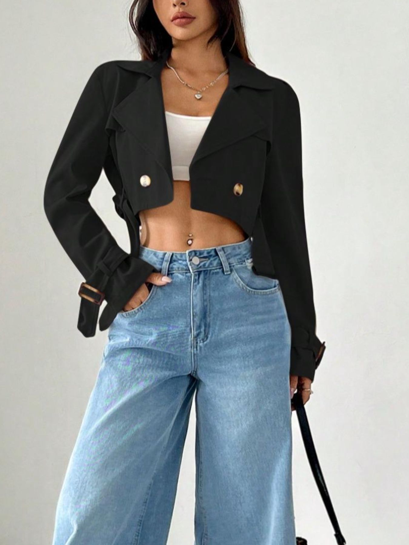 Black cropped double-breasted trench coat with gold buttons and adjustable cuffs.
