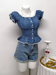 Blue ruffled smocked maternity blouse with puff sleeves, white lace trim and decorative buttons.