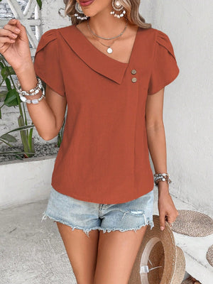Asymmetric collar top in rust orange with button detail and short sleeves.