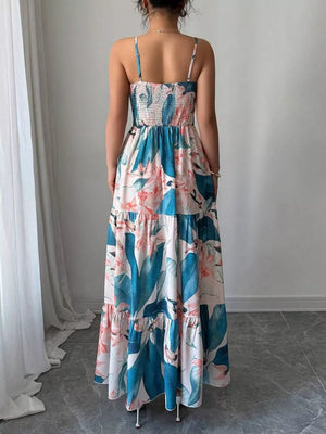 Maxi dress with tropical floral print, smocked bodice, tiered skirt, and spaghetti straps.