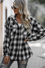 Oversized black and white plaid hooded shirt jacket with buttoned front and chest pockets.