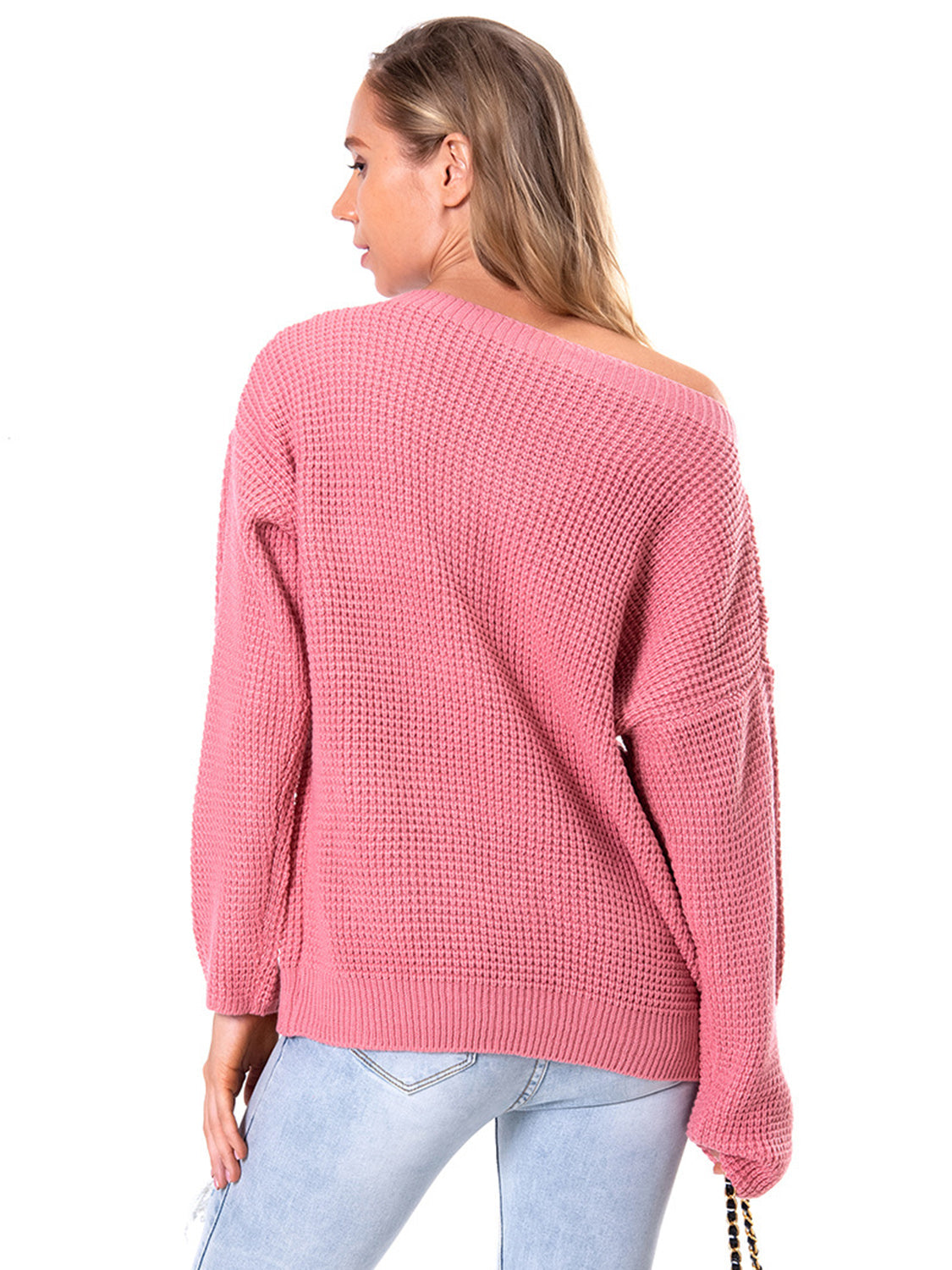 Off-shoulder waffle knit sweater in hot pink acrylic with a slouchy fit.