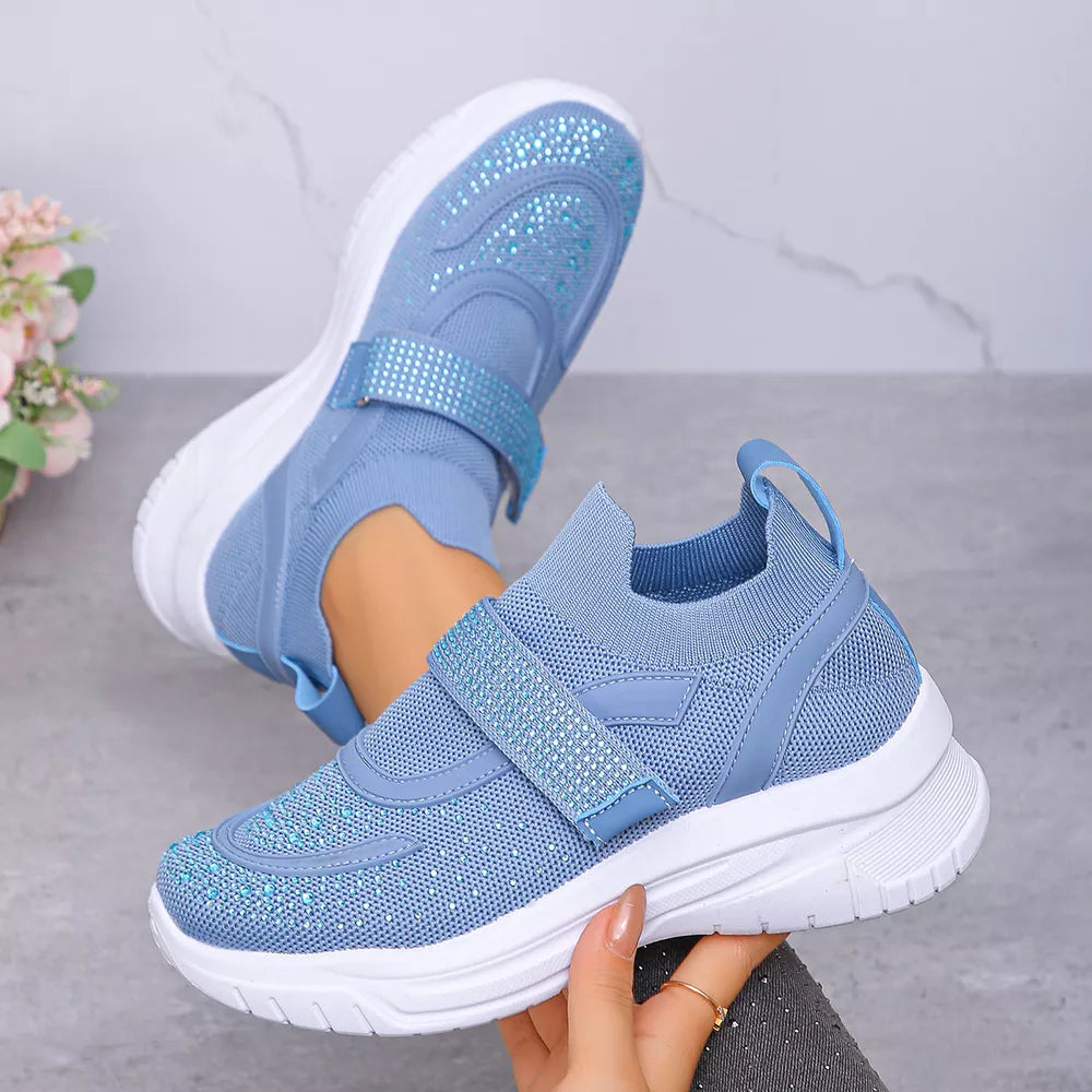 Blue mesh slip-on sneakers with adjustable straps adorned with rhinestones.
