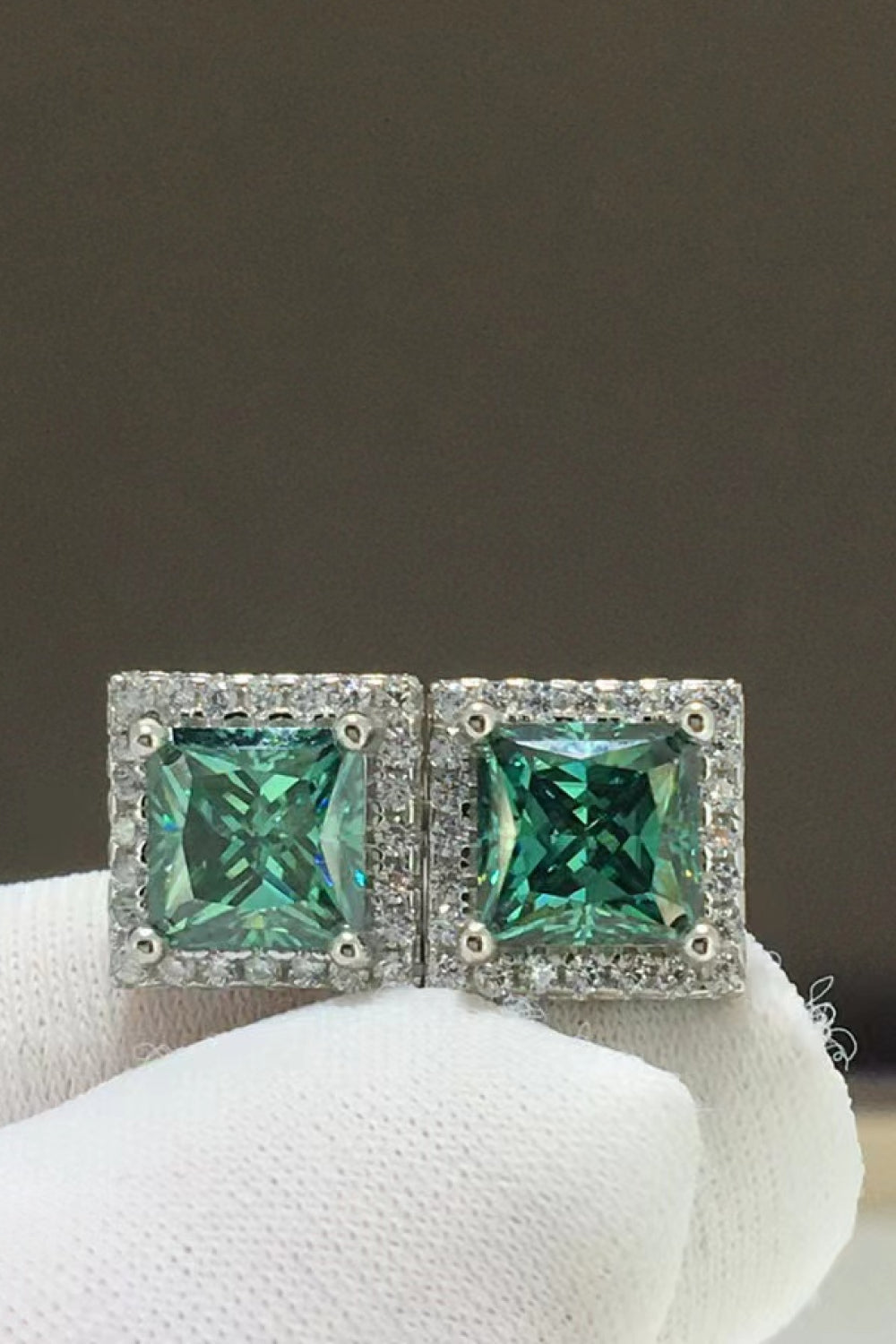 Green square stud earrings with halo of small diamonds