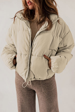 Cropped puffer jacket in cream with a hooded collar and drawstring hem.