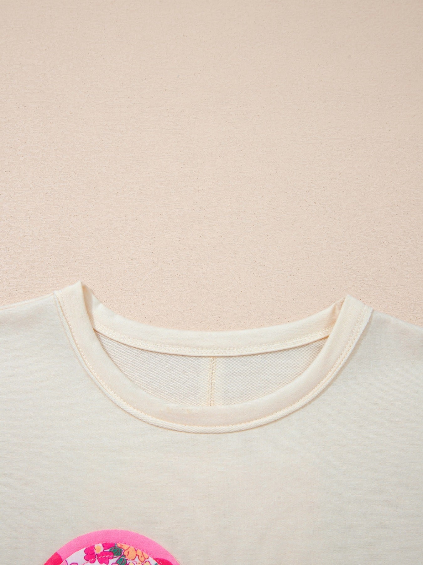 Cream cotton crew neck t-shirt with floral chenille patch detail.